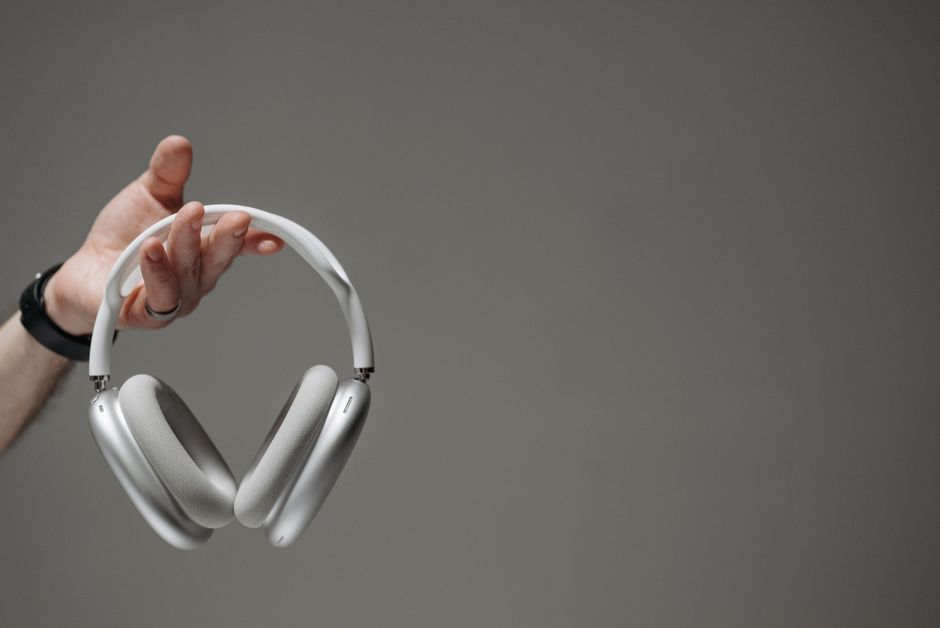 AirPods — stock photo by Pavel Danilyuk via Pexels (https://www.pexels.com/photo/a-person-holding-wireless-headphones-8000618/)